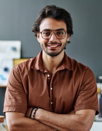 Jeune homme souriant, bras croisés