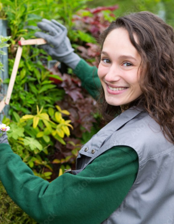 photo métier jardinage jeune femme paysagiste souriante en train de travailler